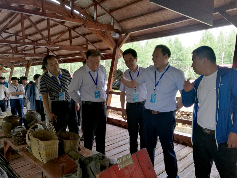 林管局領導和游客在內蒙古大興安嶺停伐紀念地參觀老一代伐木工使用過生活工具.jpg