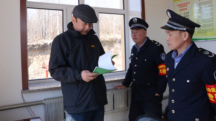 在伊圖里河林業(yè)局溫河生態(tài)功能區(qū)103檢查站，閆宏光查看檢查記錄，了解檢查站各項(xiàng)工作情況.JPG