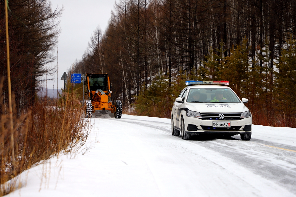 我為群眾辦實事 推雪通路保暢通圖為：民警在前方引導交通提供作業安全保障_已改.jpg